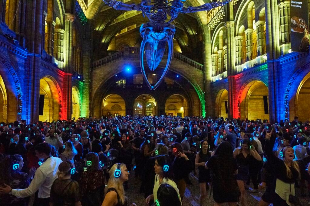 People dancing at the Silent Disco party in London at the Natural History Museum, wearing wireless headphones