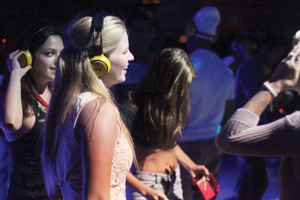 People enjoying the Silent Disco party in London at the Natural History Museum, dancing with wireless headphones