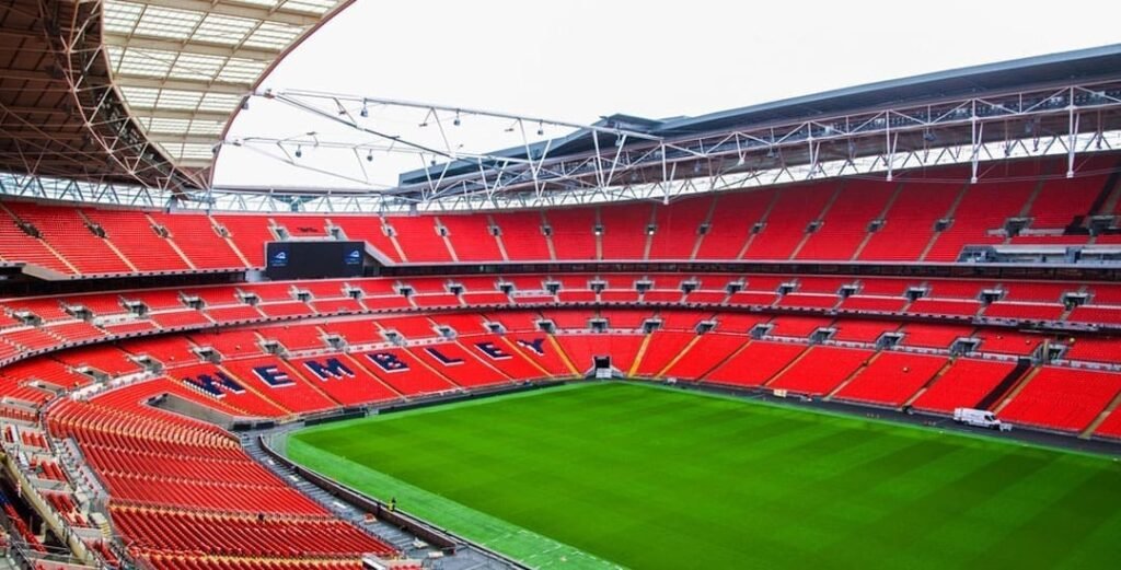 Exterior view of Wembley Stadium in London, showcasing the iconic arch and the stadium's grand entrance