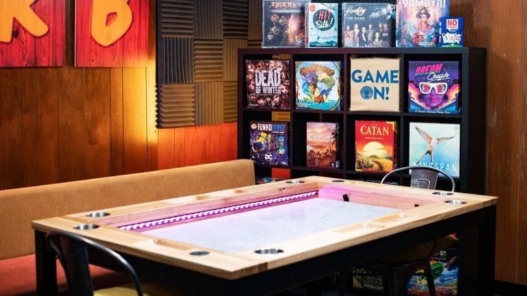 A cozy board game café with shelves full of games and vibrant street art