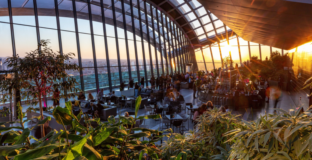 Sky Garden rooftop with indoor greenery and panoramic city views Indoor rooftop garden at Sky Garden with large glass windows and city views. | HouseToMotive | Things to do in London