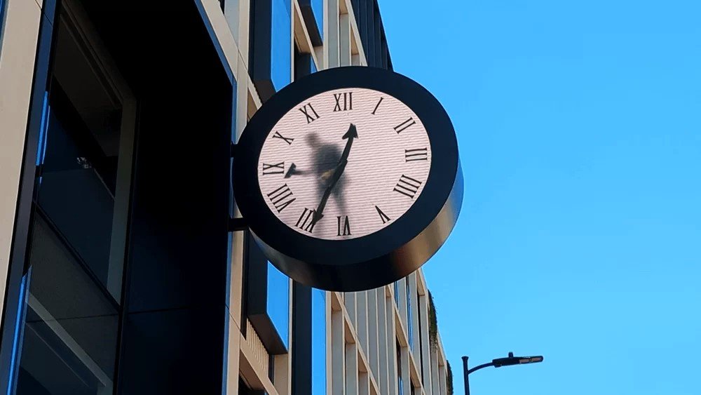 A sculpture of a tiny man inside a large clock near Paddington Station