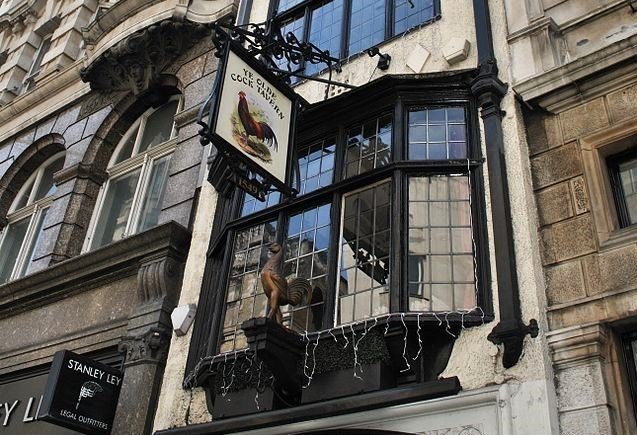 A historic and narrow Tudor-style pub with a traditional wooden exterior