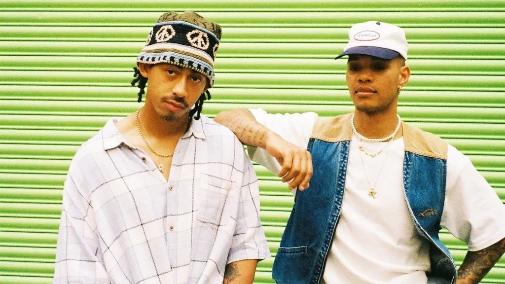 Rizzle Kicks – UK Music Duo Reunites for the 2025 UK Tour | HouseToMotive Rizzle Kicks duo, Jordan Stephens and Harley Sulé, standing together in a stylish pose