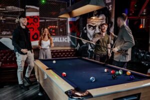 People enjoying crazy pool in London at Roxy Ball Room, 33 St Mary Axe – a fun indoor activity mixing pool and crazy golf